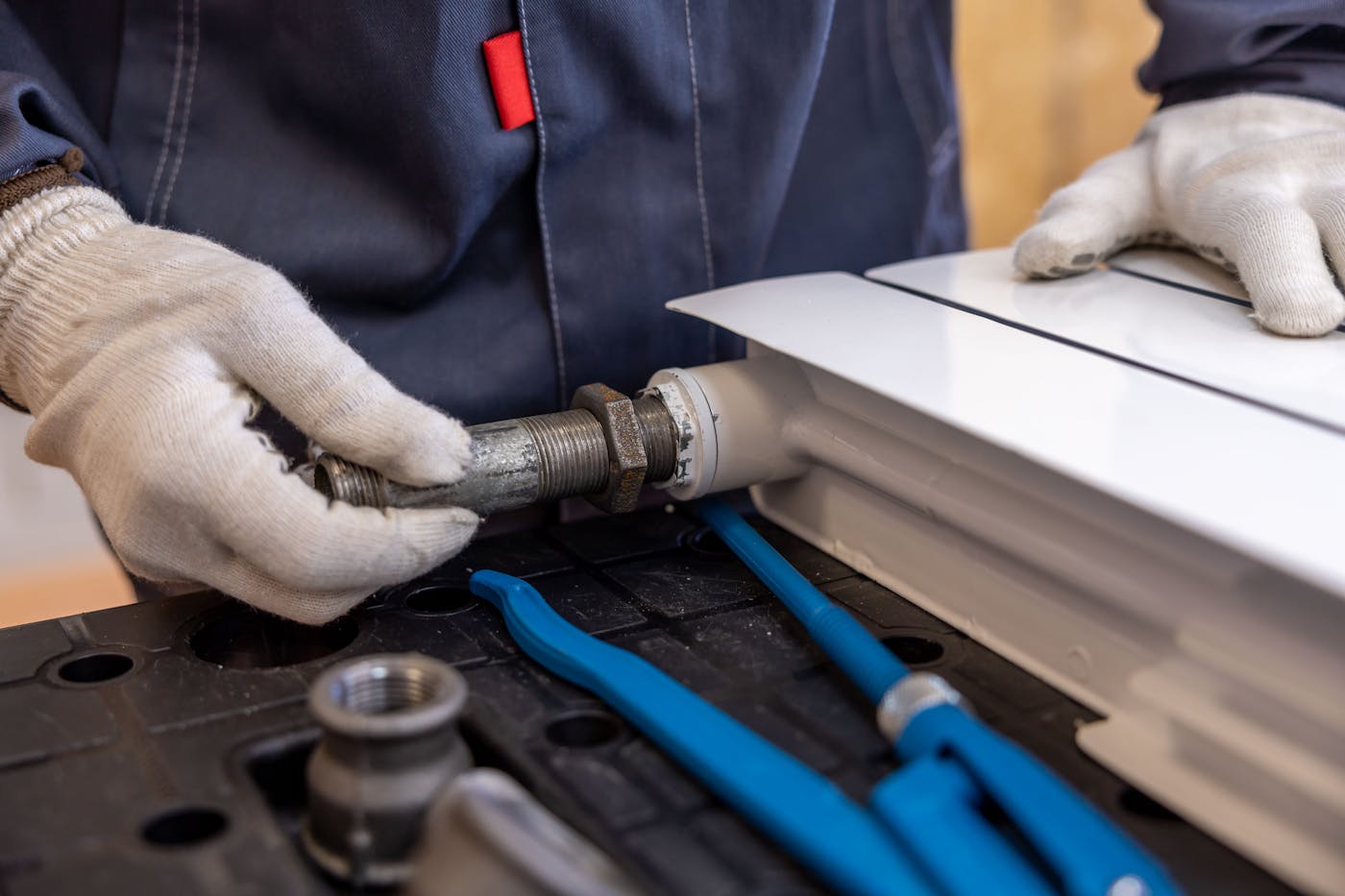 Licensed plumber fitting a pipe during a repair in a Durham Region home